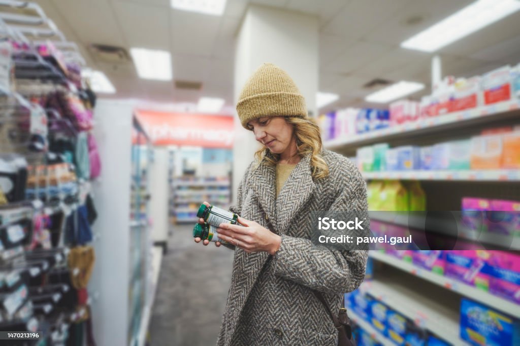 Woman shopping for multivitamins at pharmacy store